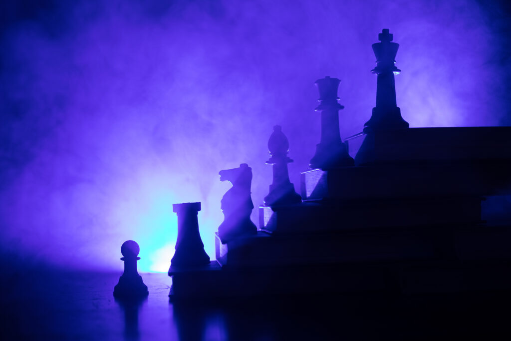 Business hierarchy. Strategy concept with chess pieces. Chess standing on a pyramid of wooden building blocks with the king at the top. copy space.